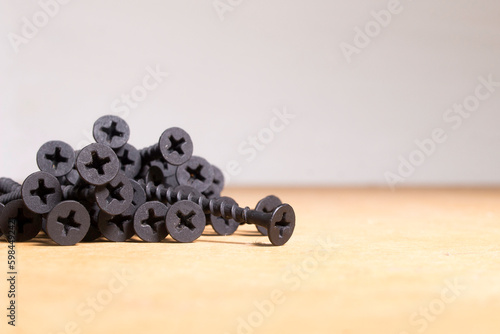 black screws on a wooden surface sorted by size