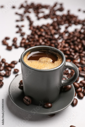 Cup of coffee and beans on grey background © Pixel-Shot