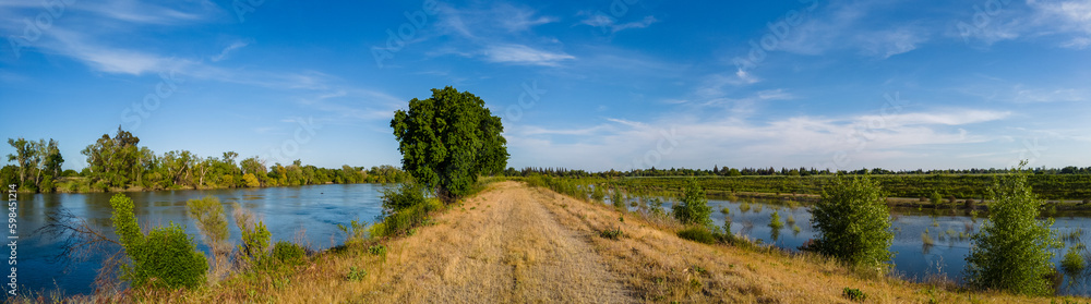 Panorama of a levee road with water on both sides 