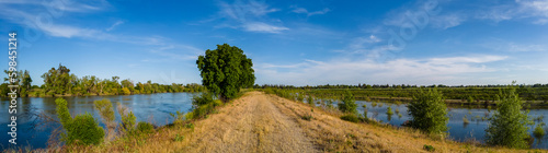Panorama of a levee road with water on both sides 