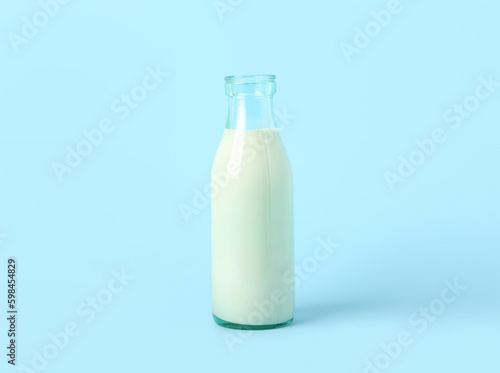 Bottle of milk on light blue background