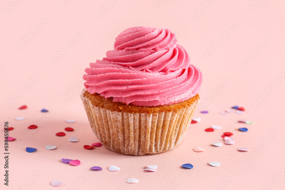 Tasty cupcake and confetti on pink background Tasty cupcake and confetti on pink background