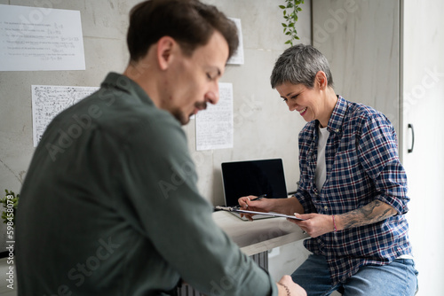 Mature senior Woman and Adult man mother and son Work in Small Office