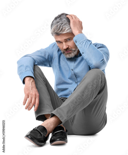 Mature businessman in stylish clothes sitting on white background