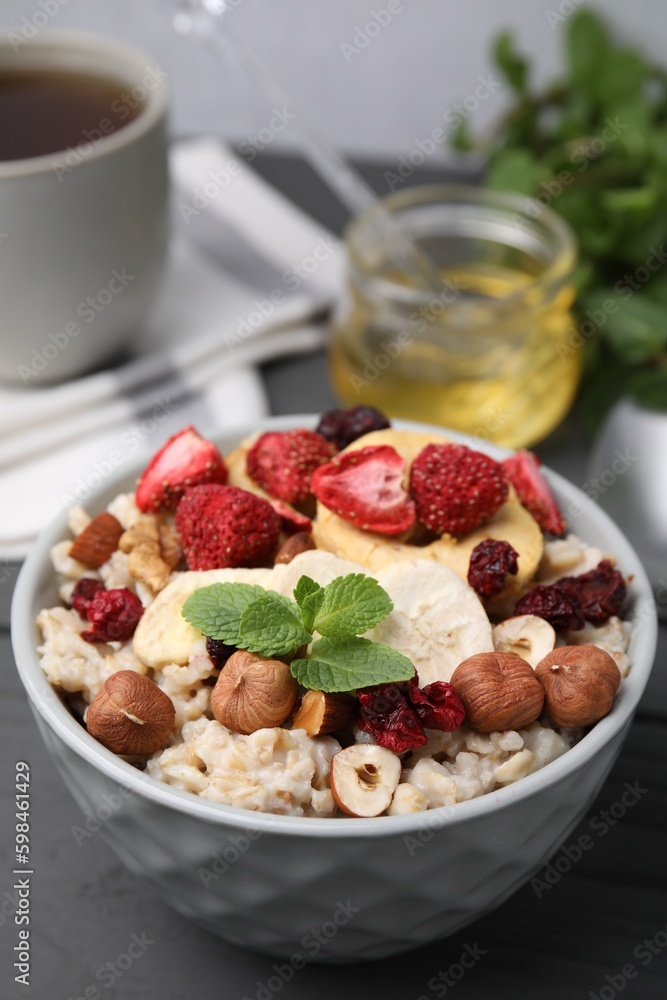 Oatmeal with freeze dried fruits, nuts and mint on grey table Oatmeal with freeze dried fruits, nuts and mint on grey table