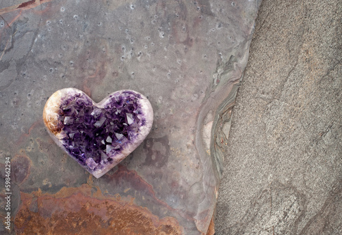 Amethyst heart on stone. Still life photography.  photo