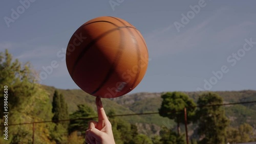 Trick with a spinning basketball ball on finger in slow motion