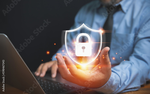 The technology of security for protect private data of personal. Technology, business, and innovation concept. Businessman holding a lock with a shield on hand to safeguard violation of privacy.