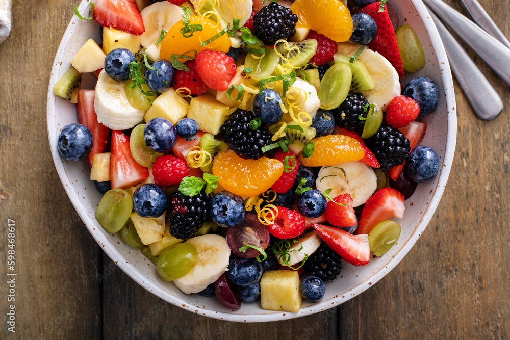 Fruit salad on a wooden table with berries and honey dressing Fruit salad on a wooden table with berries and honey dressing