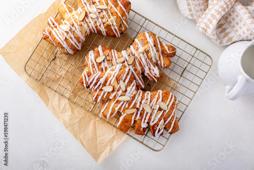 Bear claw pastry on a cooling rack with glaze and almonds photo