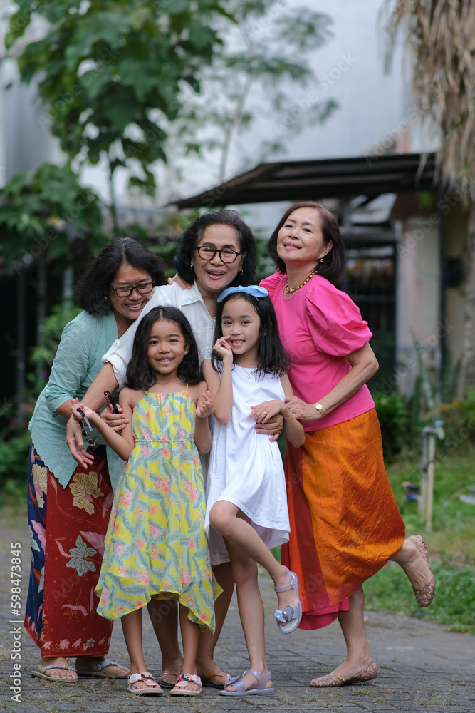 Fototapeta premium Three mothers posing with their two beautiful daughters together