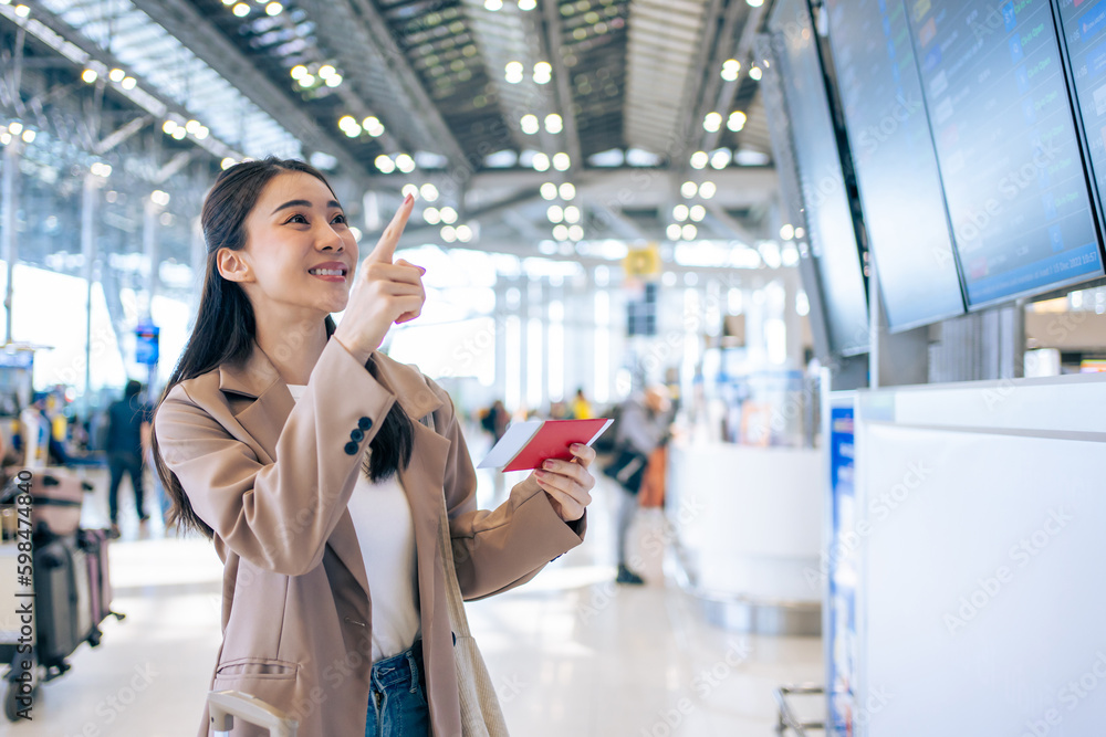 Asian young woman passenger checking depature boarding pass in airport. Asian young woman passenger checking depature boarding pass in airport.