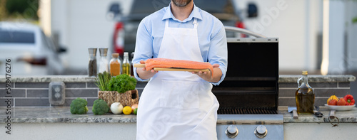 Photography cropped view of man barbecuing trout fillet outdoor