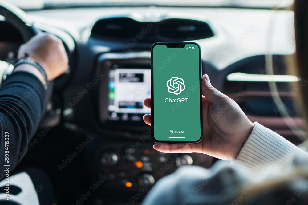 Girl inside car holding smartphone with ChatGPT artificial intelligence
