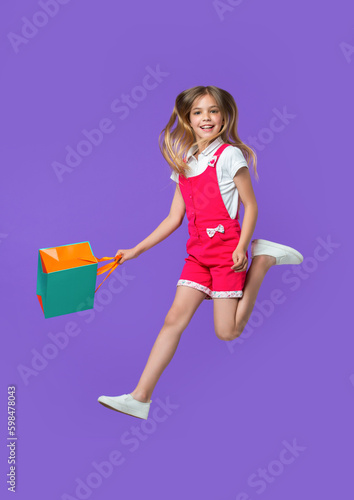 image of teen girl jumping after shopping. teen girl jumping after shopping