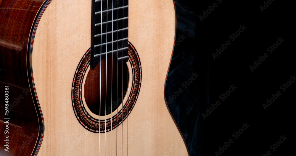 Close up shot of Classical guitar show the rosette around sound hole , black background Close up shot of Classical guitar show the rosette around sound hole , black background