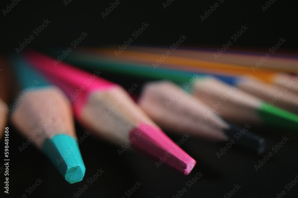 Sharpened multi-colored pencil tips on dark background Sharpened multi-colored pencil tips on dark background