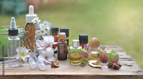 bottles of essential oil with plant and flower and aromatherapy equipment on ...