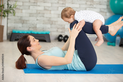 young mother does physical fitness exercises with her baby