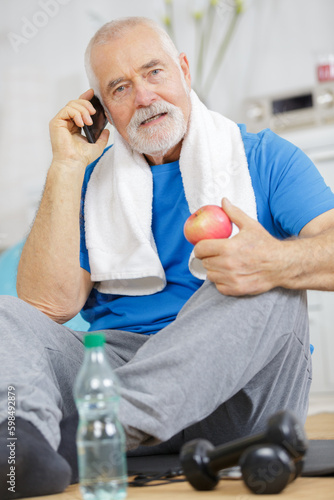 mature man with apple on white background