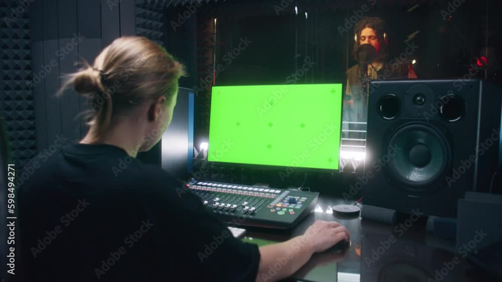 Pruducer Screen Video Stock Male singer records song in soundproof room. Female audio ...