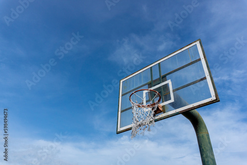 Low angle view of basketball ring on sky background. Outdoor basketball hoop.