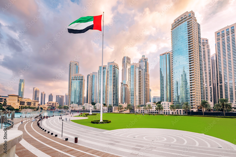 Scenic view of Dubai skyline, with the skyscraper buildings and national flag. Sightseeing and travel destinations in Arab Emirates
