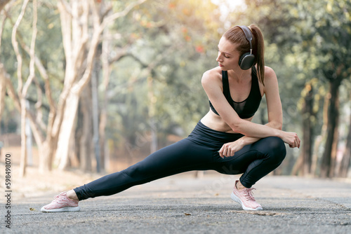 Young beautiful woman in sports outfits doing stretching before workout outdoor in the park to get a healthy lifestyle.