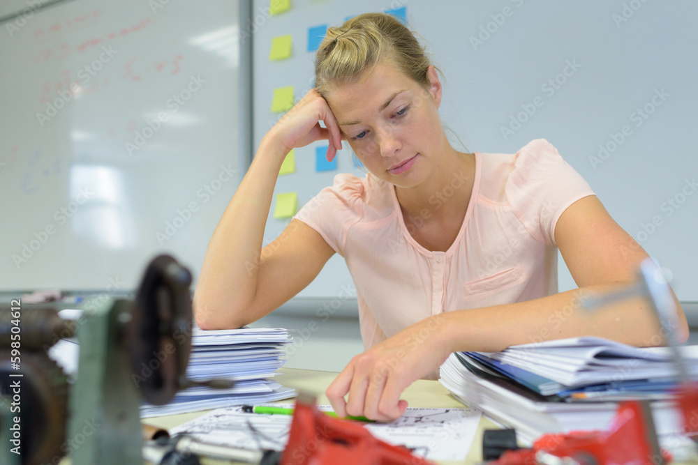 distressed secretary with pile of documents folders bills on desk distressed secretary with pile of documents folders bills on desk