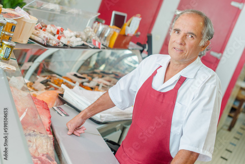 Принти на полотні a butcher standing behind counter