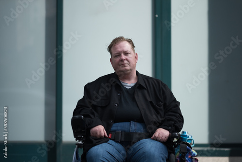 Pausing in front of a storefront with strong vertical features, a disabled transman in his powerchair expresses notions of public space. He is thriving but also affirms the urgency of accessibility.