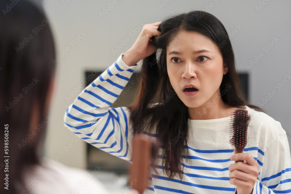 shocked woman suffering hair loss problem with hairbrush in mirror at home shocked woman suffering hair loss problem with hairbrush in mirror at home