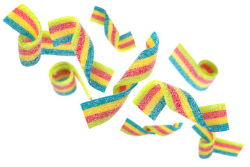 Levitation of colored jelly candy strips in sugar sprinkles isolated on transparent background.
