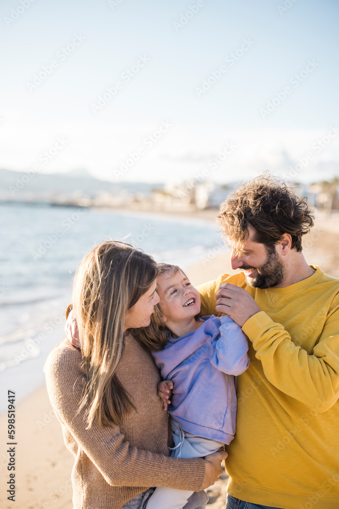 Father and mother playing with daughter at beach Father and mother playing with daughter at beach