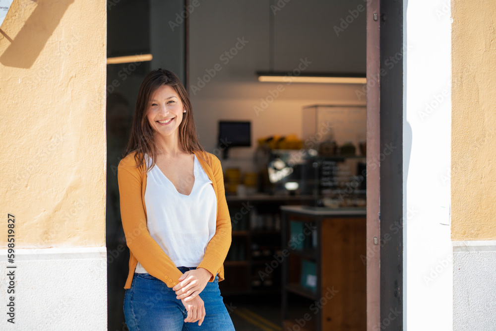 Smiling owner standing at coffee shop doorway Smiling owner standing at coffee shop doorway