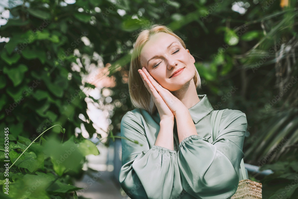 Smiling woman with hands clasped and eyes closed Smiling woman with hands clasped and eyes closed