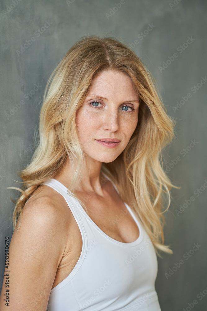 Blond woman leaning on gray wall Blond woman leaning on gray wall