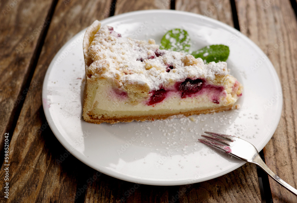 Cheesecake with cherries ready to eat on a plate outdoors