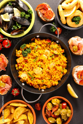 Assorted Spanish food set Paella seafood platters,  mussels,  fried onion rings, patatas bravas, olives