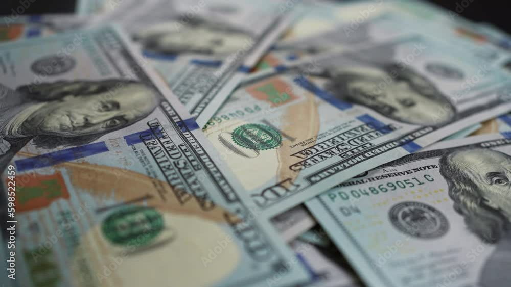 Hundred dollar bills falling on spinning table in a pile of cash. A heap of money growing larger and larger as additional banknotes raining down. Concept of business and finance Hundred dollar bills falling on spinning table in a pile of cash. A heap of money growing larger and larger as additional banknotes raining down. Concept of business and finance