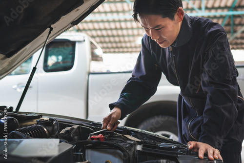 Portrait of a mechanic repairing a car in garage, Auto mechanic working in garage, Maintenance and Repair service. © Poguz.P