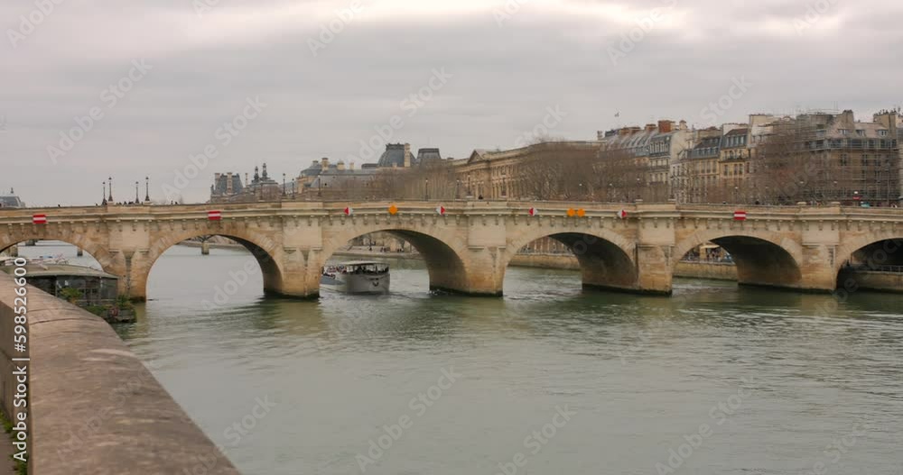 Scenic View Of A Tourist Boat At Seine River Passing Underneath The Pont Neuf In Paris, France. wide shot Scenic View Of A Tourist Boat At Seine River Passing Underneath The Pont Neuf In Paris, France. wide shot