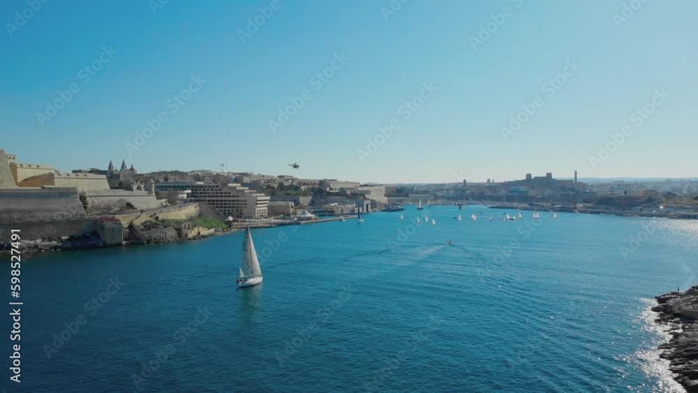 Aerial of port with sailing boats and helicopter flying with a city landscape Aerial of port with sailing boats and helicopter flying with a city landscape