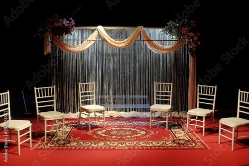 Stage performance with classic decor, curtains, red carpet and props seats.