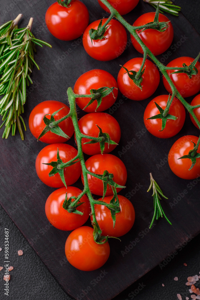 Delicious fresh cherry tomatoes on a twig with spices and herbs Delicious fresh cherry tomatoes on a twig with spices and herbs