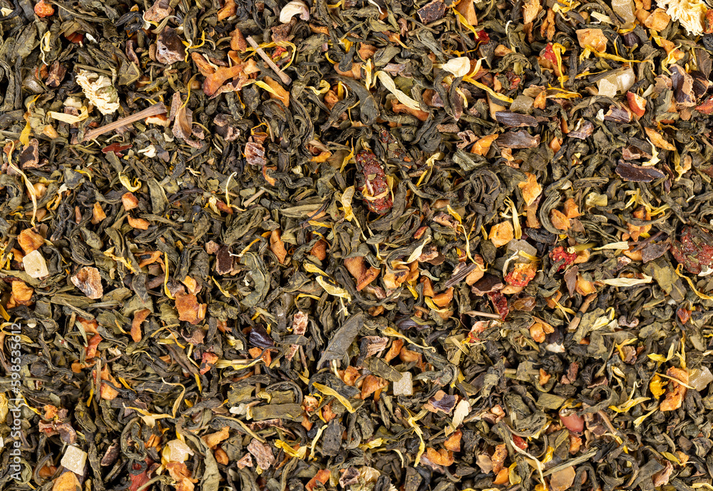 A large amount of dry green tea with pieces of fruit A large amount of dry green tea with pieces of fruit