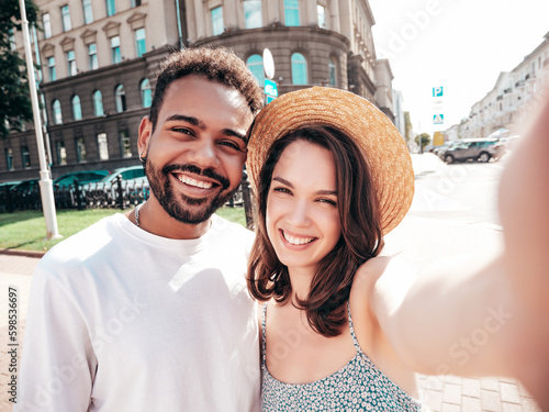 Smiling beautiful woman and her handsome boyfriend. Woman in casual summer clothes. Happy cheerful family. Female having fun. Sexy couple posing in the street at sunny day. Taking selfie