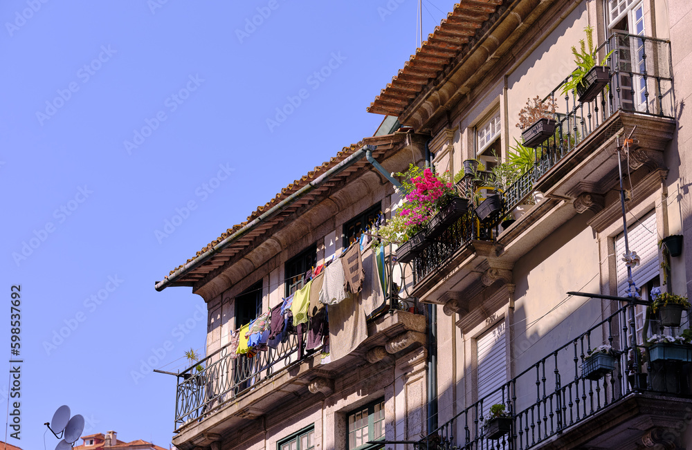 Typical Portuguese houses, covered with colorful azulejos, in the historic part of the city of Porto, Portugal. Details of house facades, windows, balconies, railings, colored ceramics.