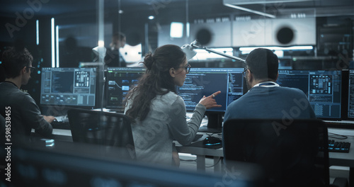 Diverse Young Colleagues Working on Computers in a Research Laboratory. Female Asking Advice from a Male Software Developer Colleague About a Solution for Their Collaborative Industrial Tech Project