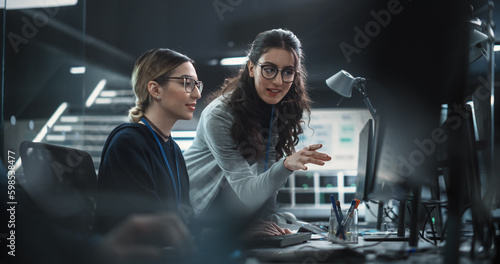 Two Diverse Colleagues Having a Conversation While Busy Working on a Team Project. Multiethnic Female Designer Talking with a Project Manager. Teamwork in Technology Laboratory